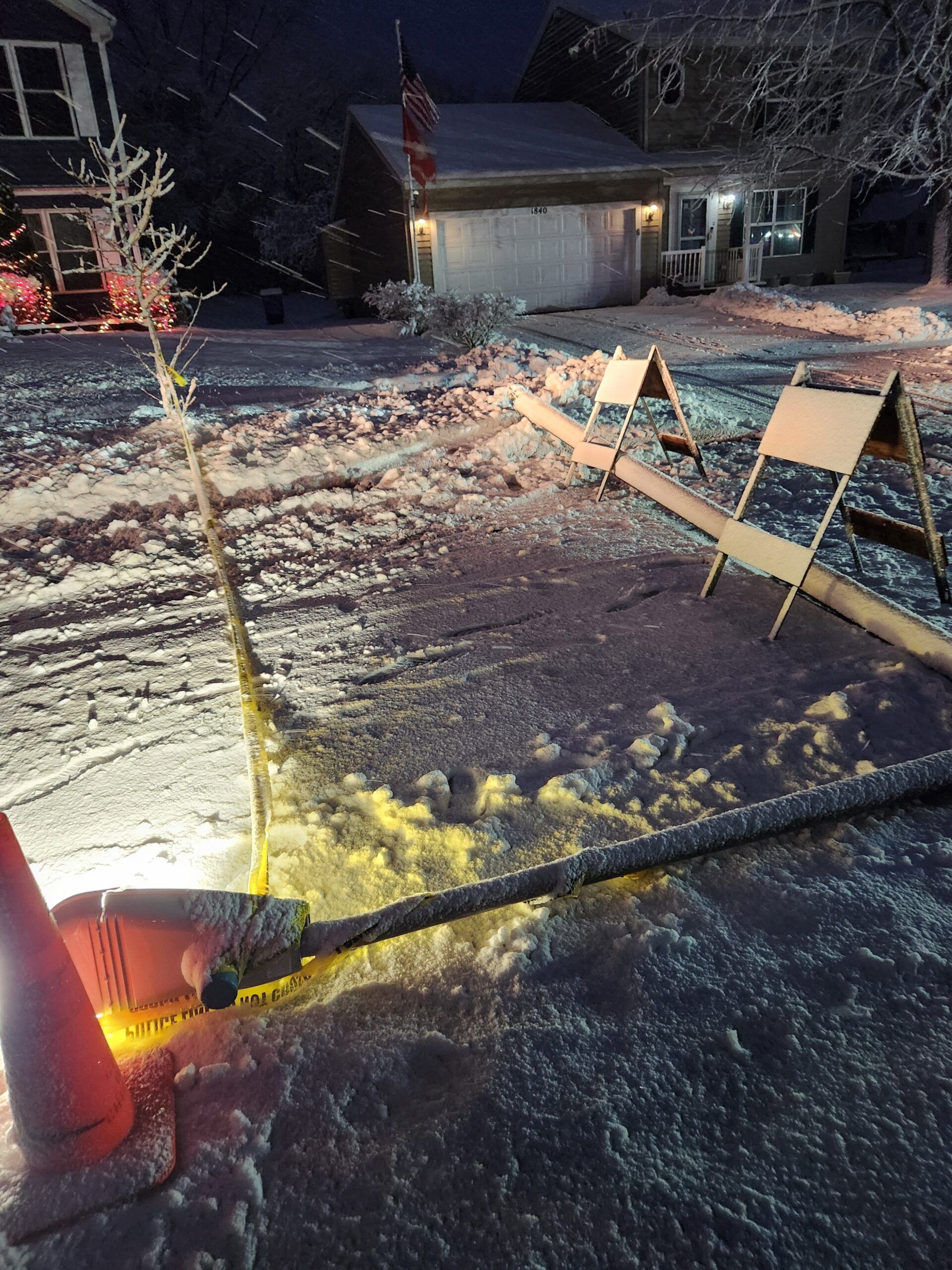 A snowy yard with a house in the background