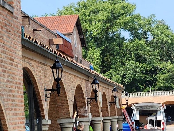 A brick building with arches and lanterns on the side