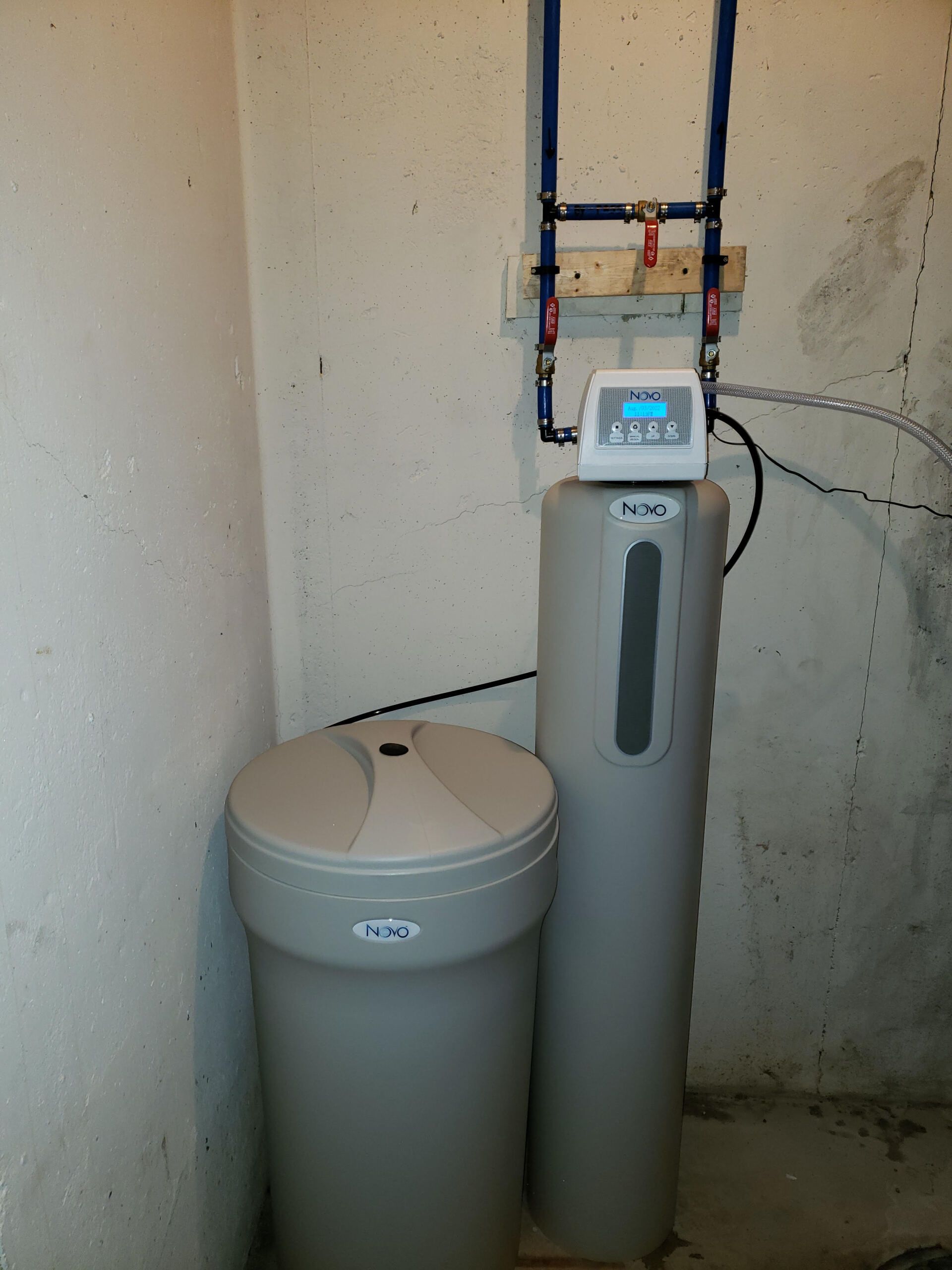 A water softener is sitting in a corner of a room