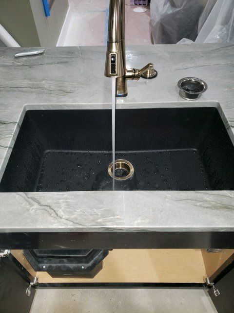 A kitchen sink with water coming out of the faucet