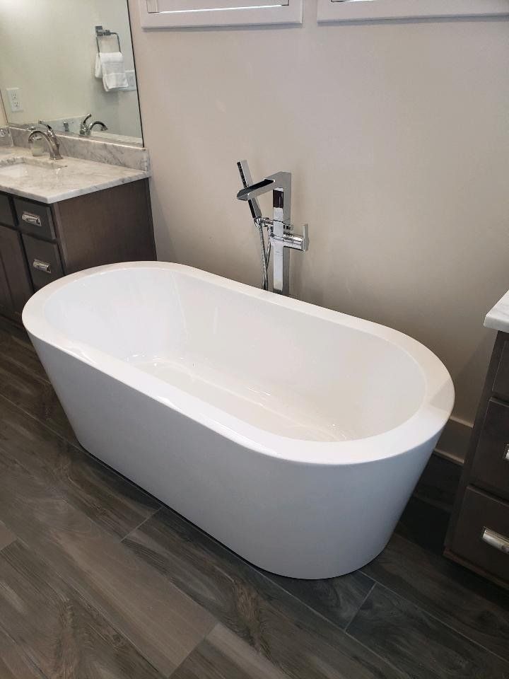 A white bathtub is sitting in a bathroom next to a sink.