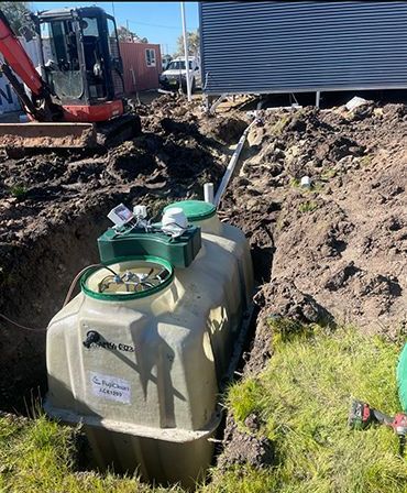 A Septic Tank Is Being Installed In A Hole In The Ground — Pertzels Plumbing In Wagga Wagga, NSW