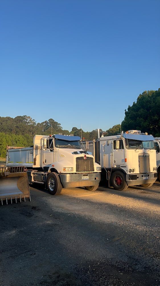 Two Semi Trucks Are Parked Next To Each Other — Wilsons Excavations & Plant Hire in Tweed Heads, NSW