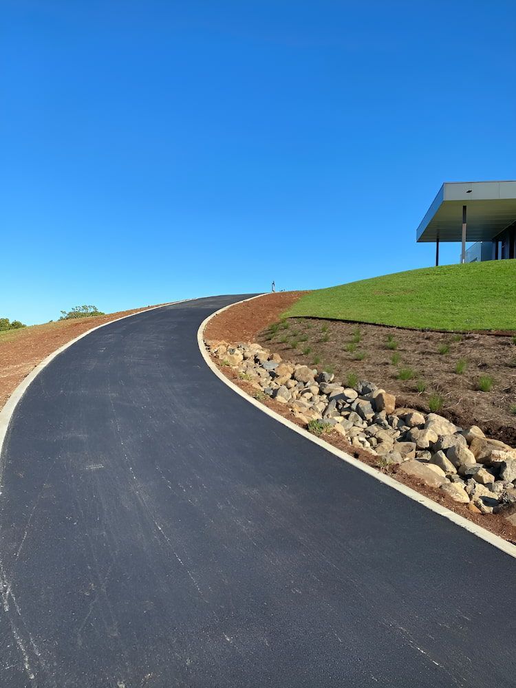 A Curvy Road With A House — Wilsons Excavations & Plant Hire in Myocum, NSW
