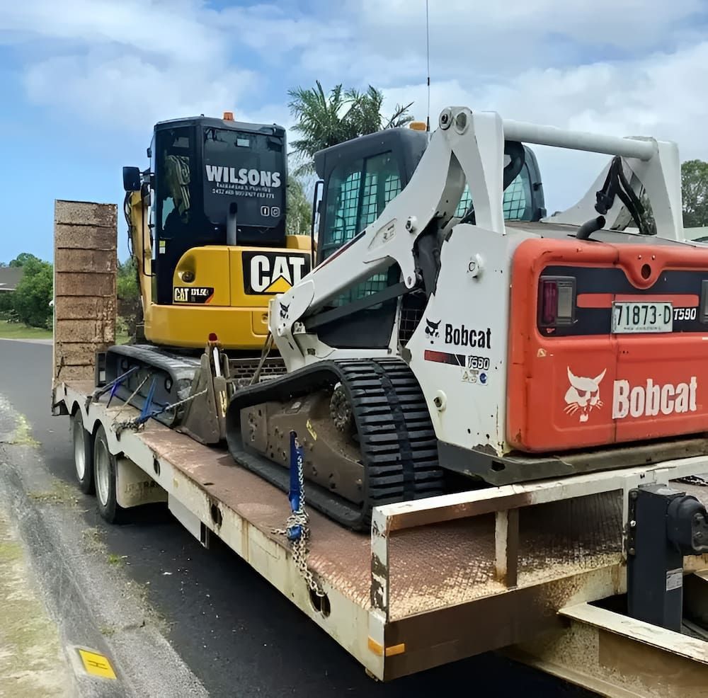 A Bulldozer And A Bobcat Are On A Trailer — Wilsons Excavations & Plant Hire in Myocum, NSW