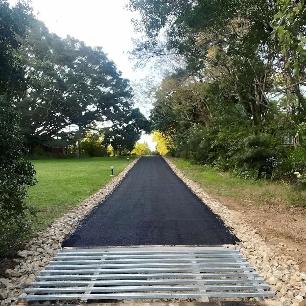 A Road With A Metal Grate On The Side Of It — Wilsons Excavations & Plant Hire in Myocum, NSW