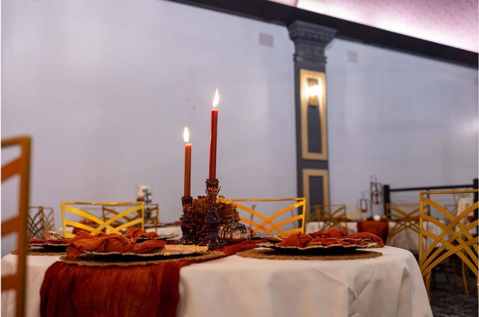 a table set for a wedding reception with candles on it .