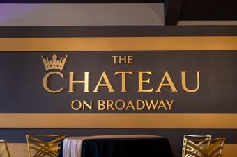 a table and chairs in front of a sign that says the chateau on broadway