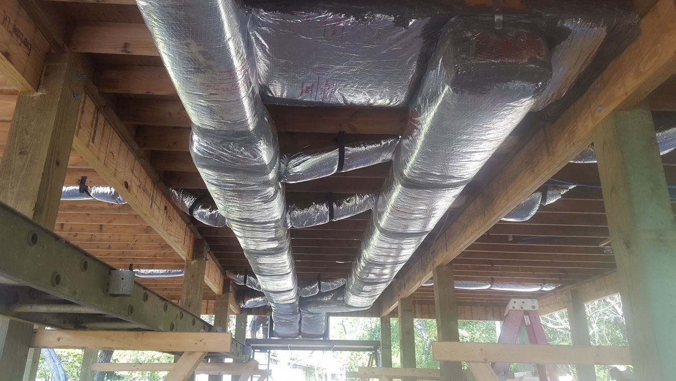 A bunch of pipes are hanging from the ceiling of a building.