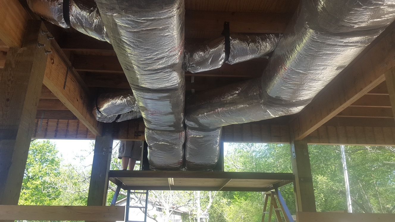 A bunch of pipes are hanging from the ceiling of a building.