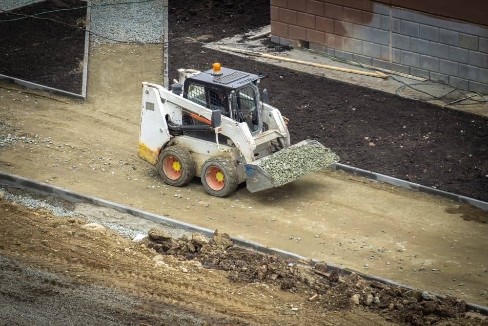A Bulldozer is Moving Dirt on a Construction Site — Matt's Mini Machines in Caloundra, QLD