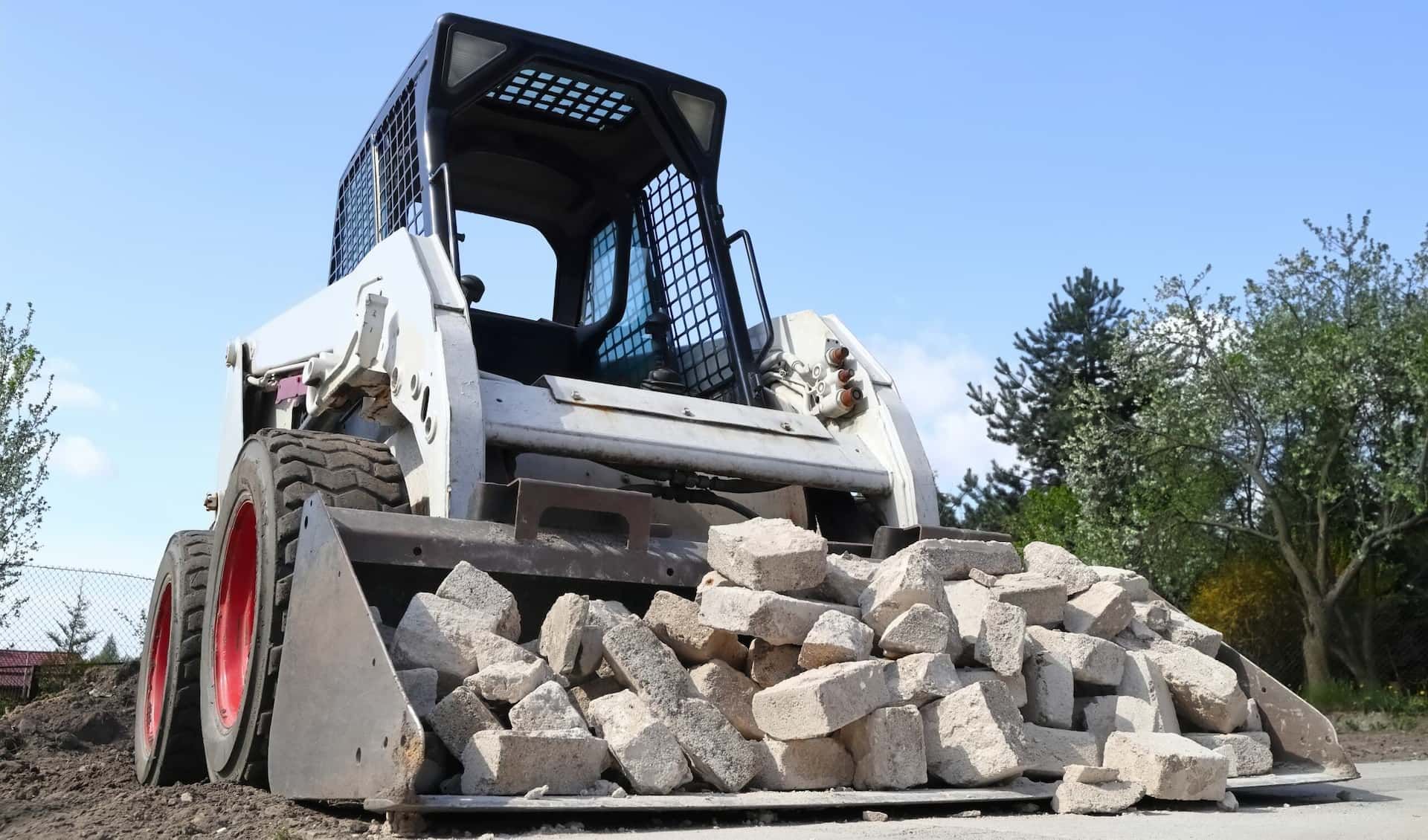 A Bulldozer is Moving a Pile of Rocks on a Road — Matt's Mini Machines in Buderim, QLD