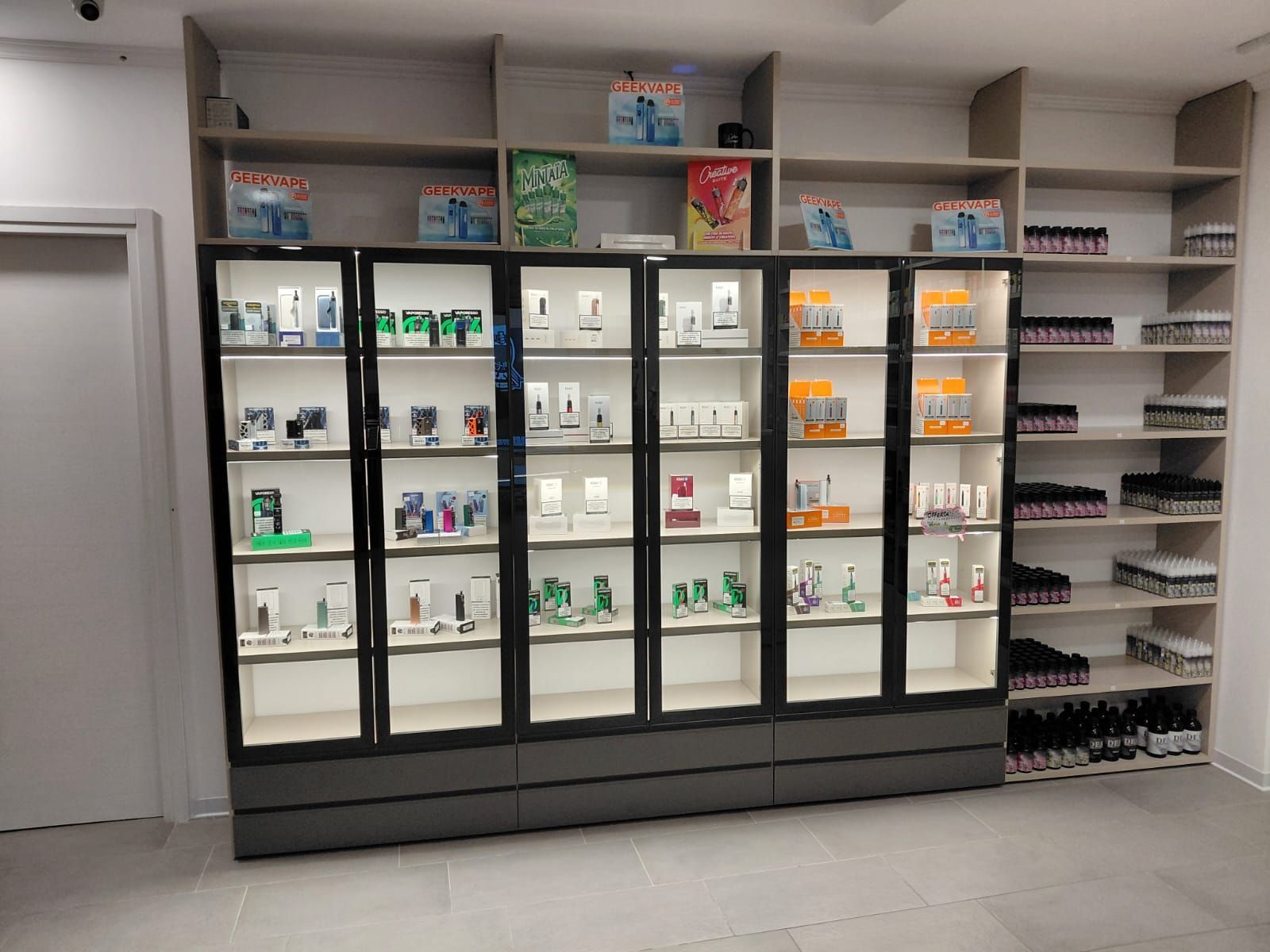 Vetrine con prodotti illuminati, scaffali con articoli confezionati, all'interno di un negozio.