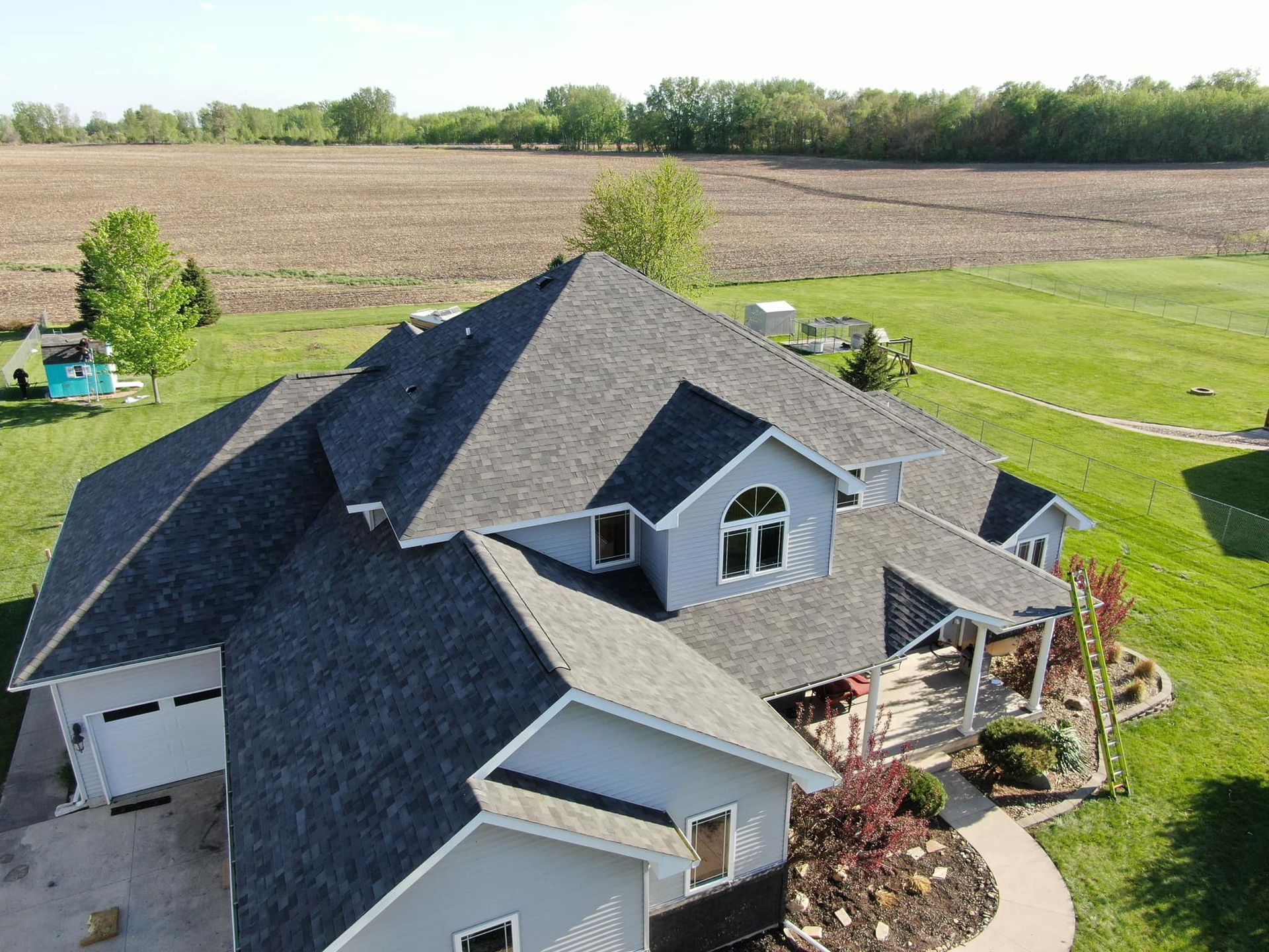 An aerial view of a large house with a gray roof