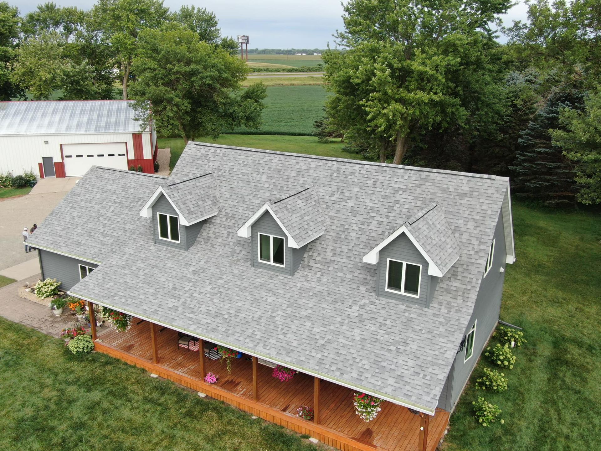 An aerial view of a house with a gray roof