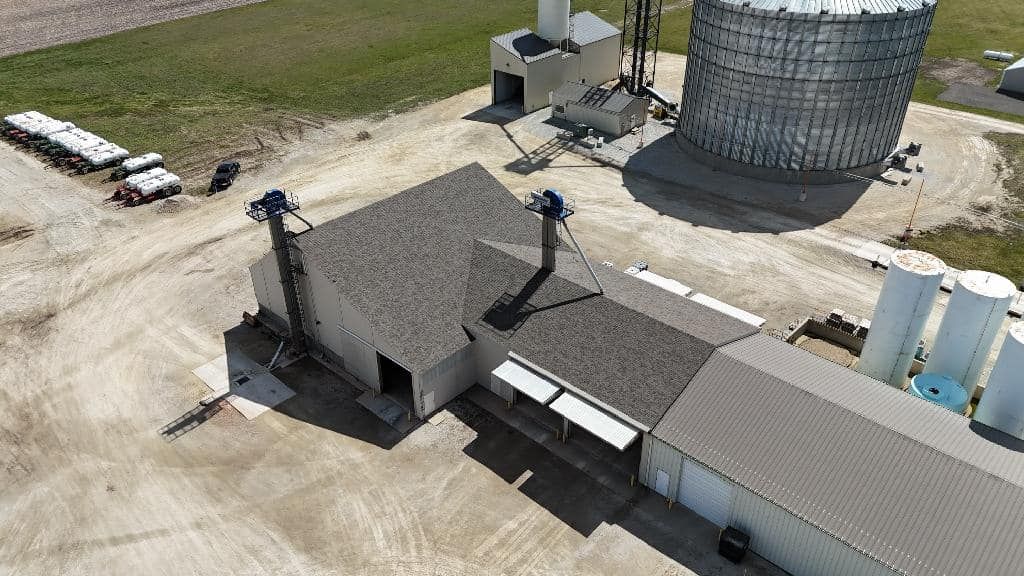 An aerial view of a farm with a barn and silos.