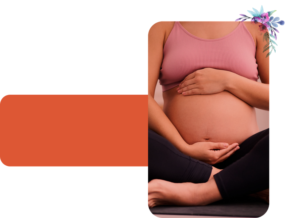 A pregnant woman is sitting on a yoga mat holding her belly.