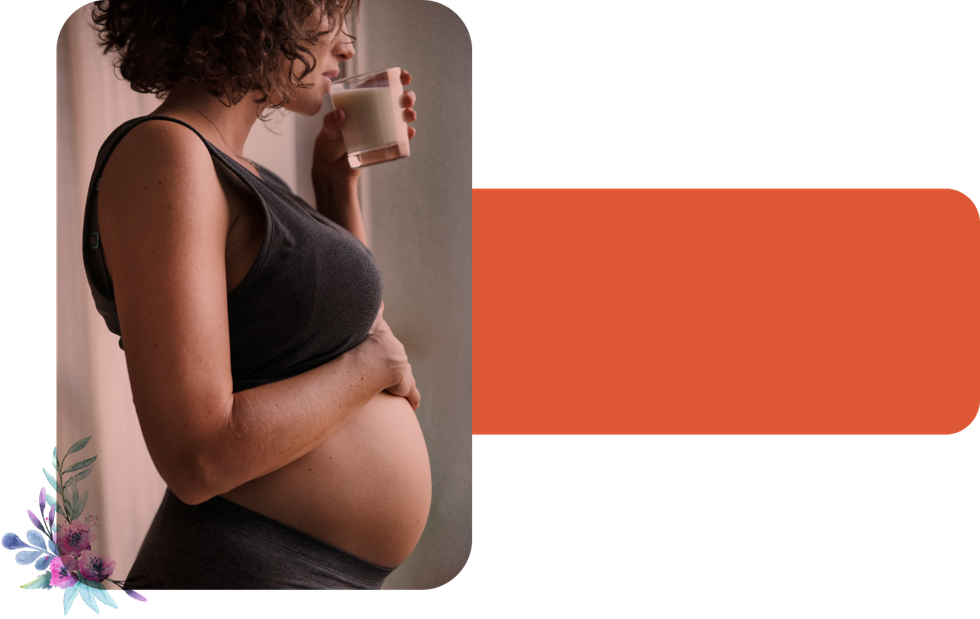 A pregnant woman is drinking a cup of milk.