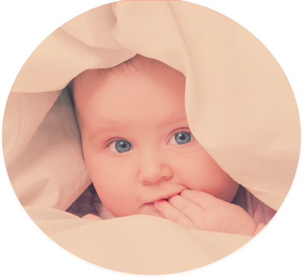 A baby is peeking out from under a blanket