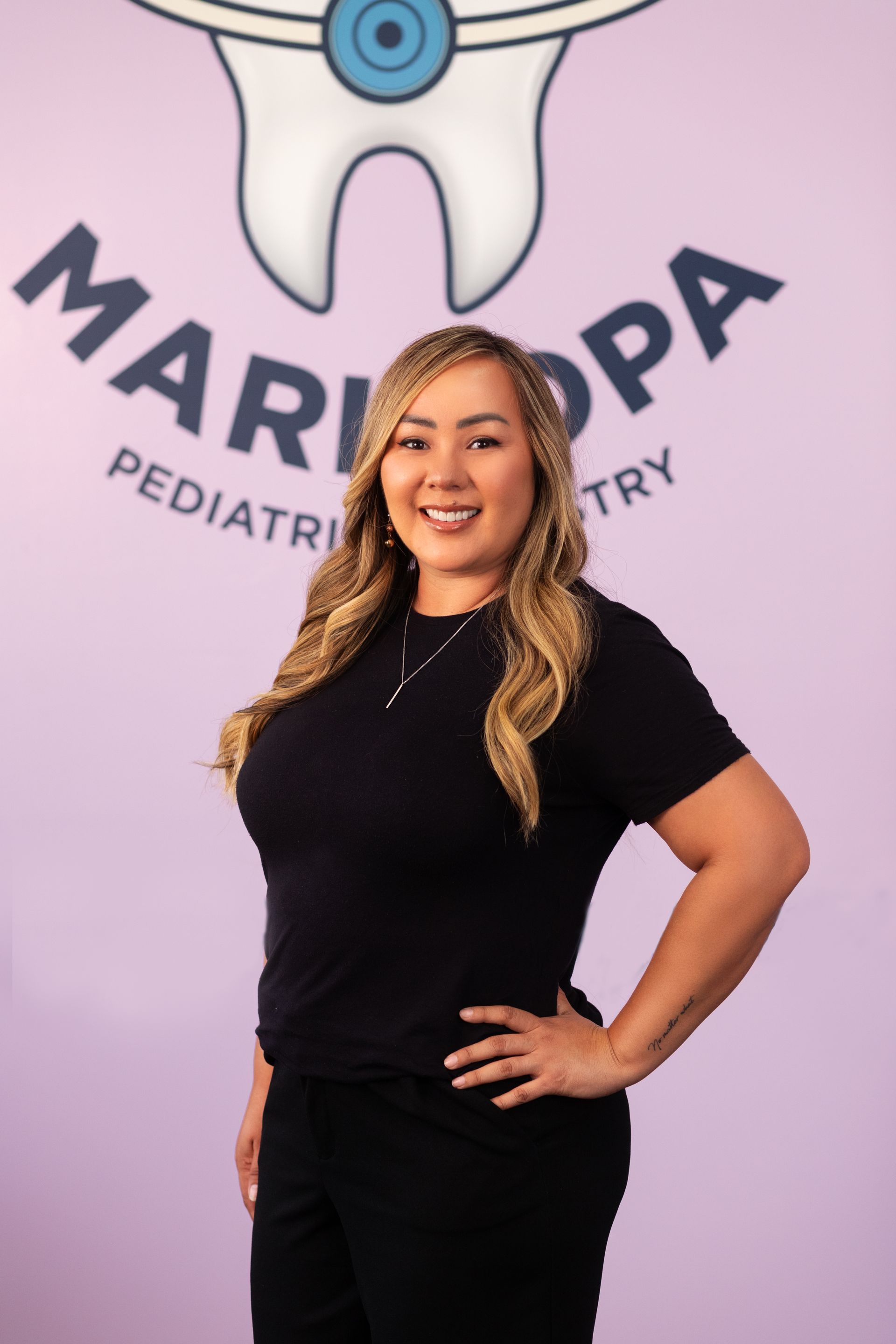 A woman is standing in front of a sign that says maricopa pediatrics