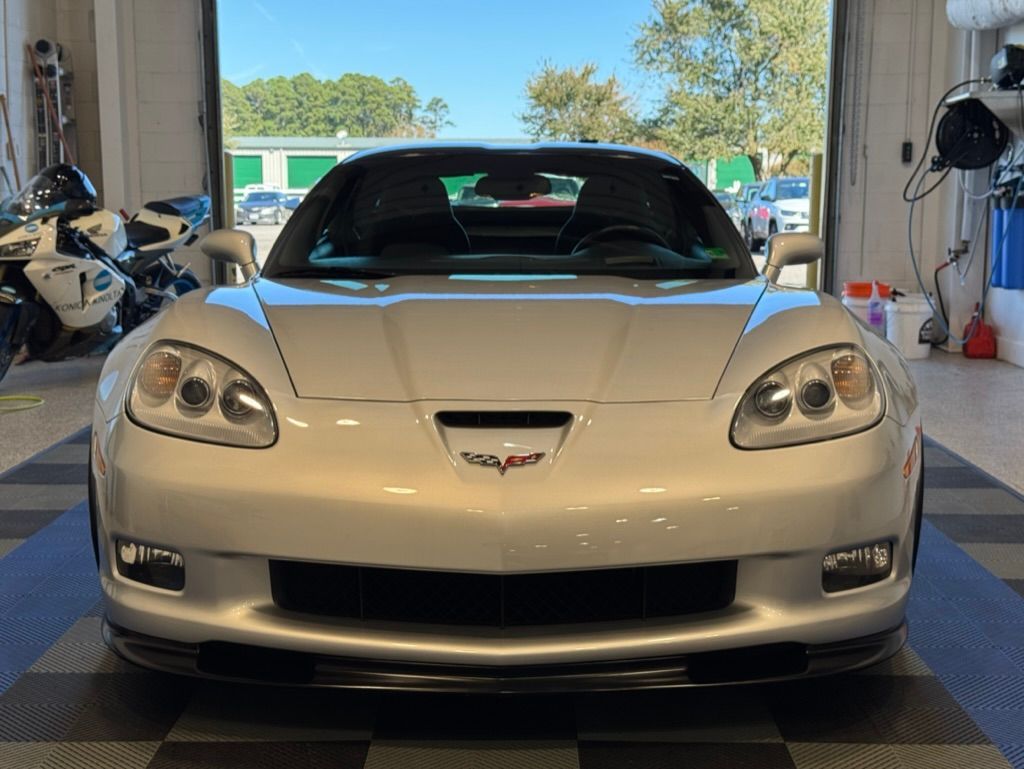 A person is cleaning a car with a blue cloth.