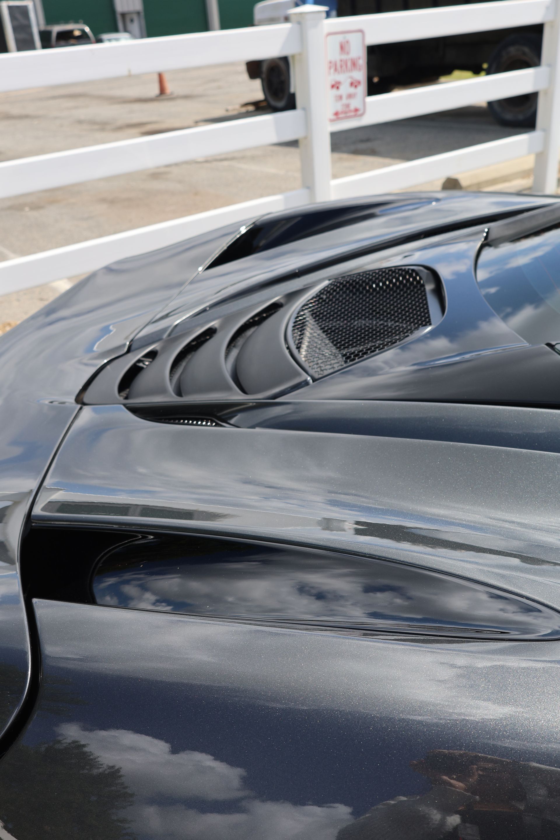 A person is cleaning a car with a blue cloth.