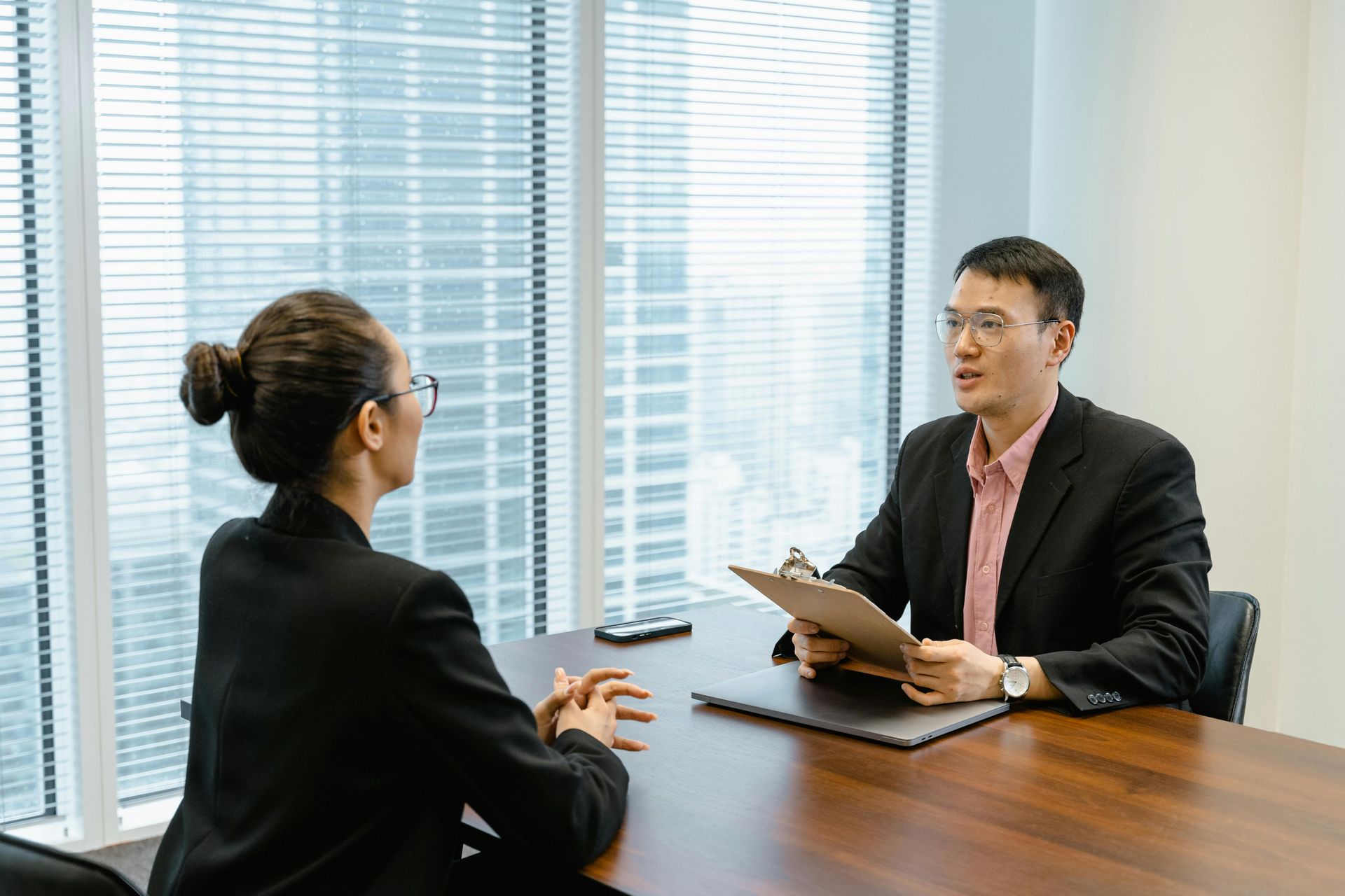 A woman is sitting at a table having a job interview.