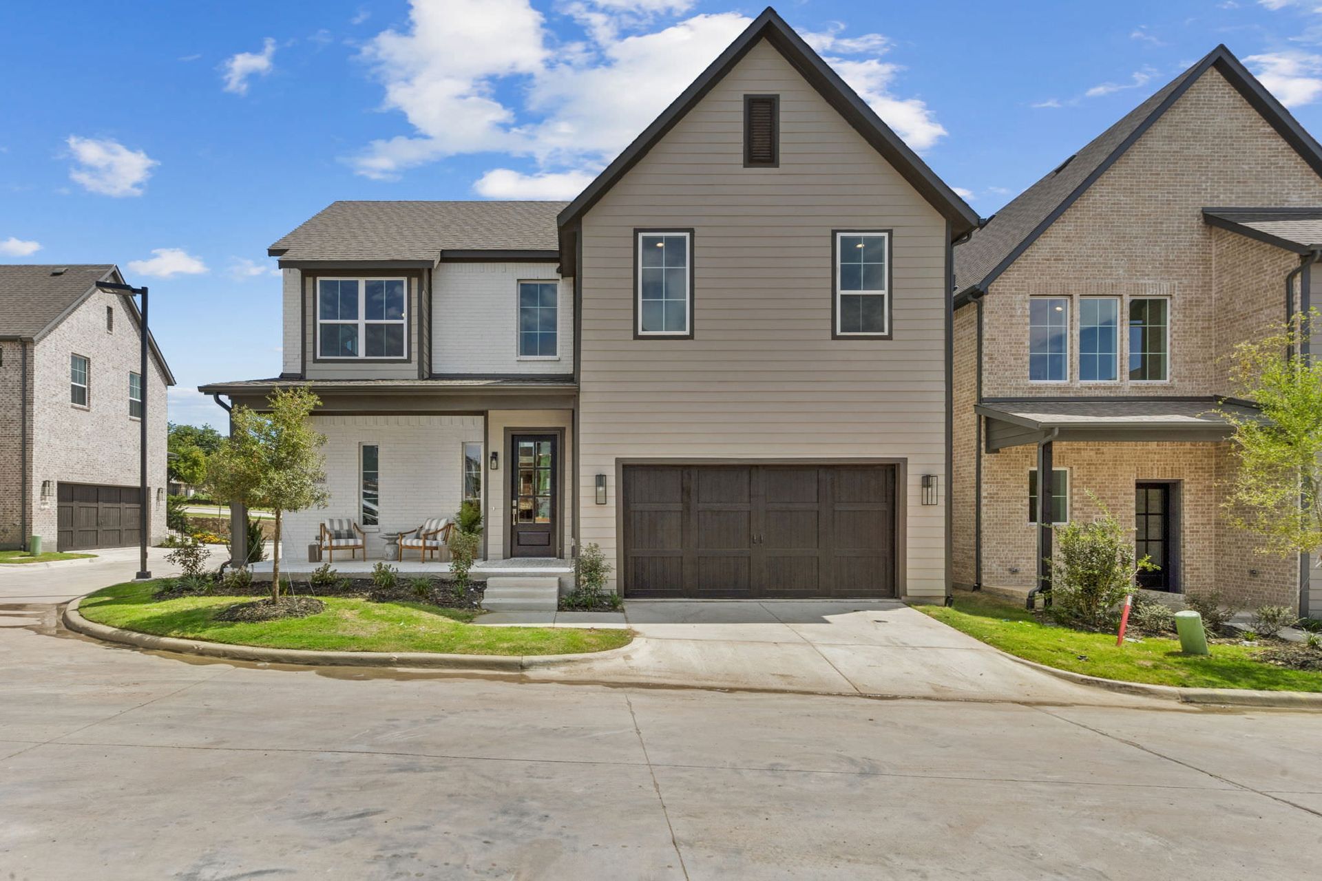 Modern two-story home with gray and white siding, a brown garage door, and a small front porch.
