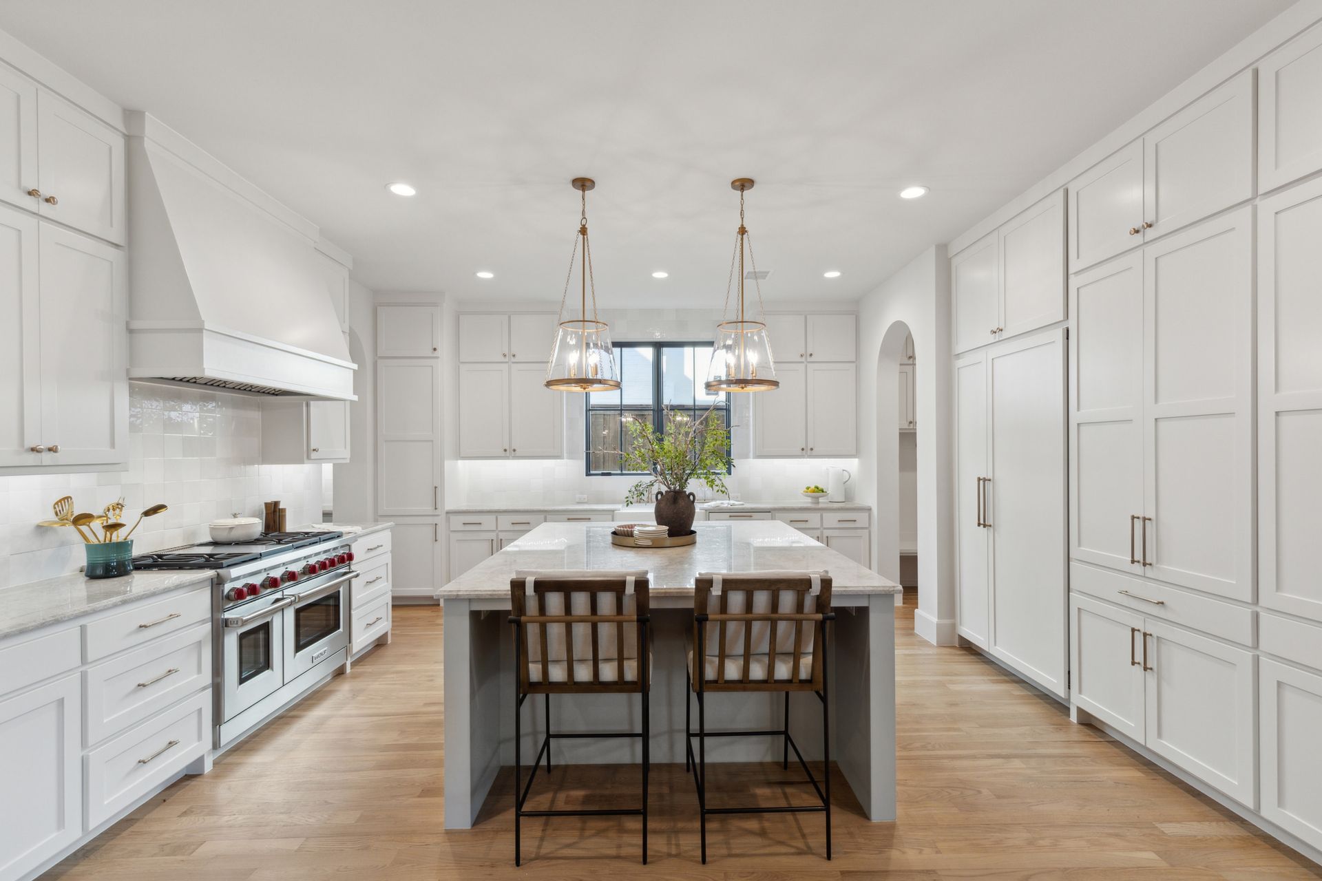A large kitchen with white cabinets and a large island.