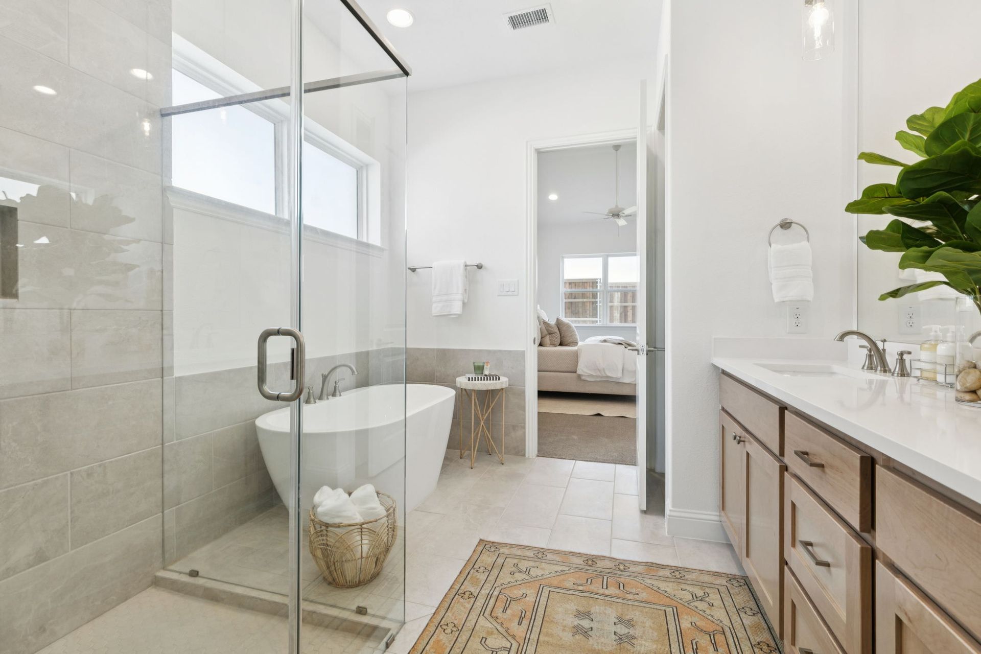 Modern bathroom with glass shower, freestanding tub, and neutral tones.