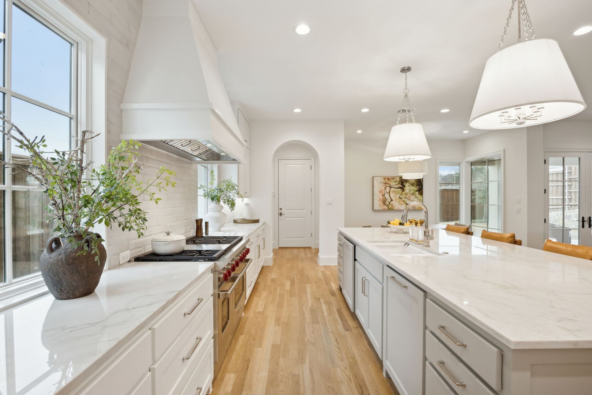 Bright, modern kitchen with white cabinets, wooden floors, and a long island.