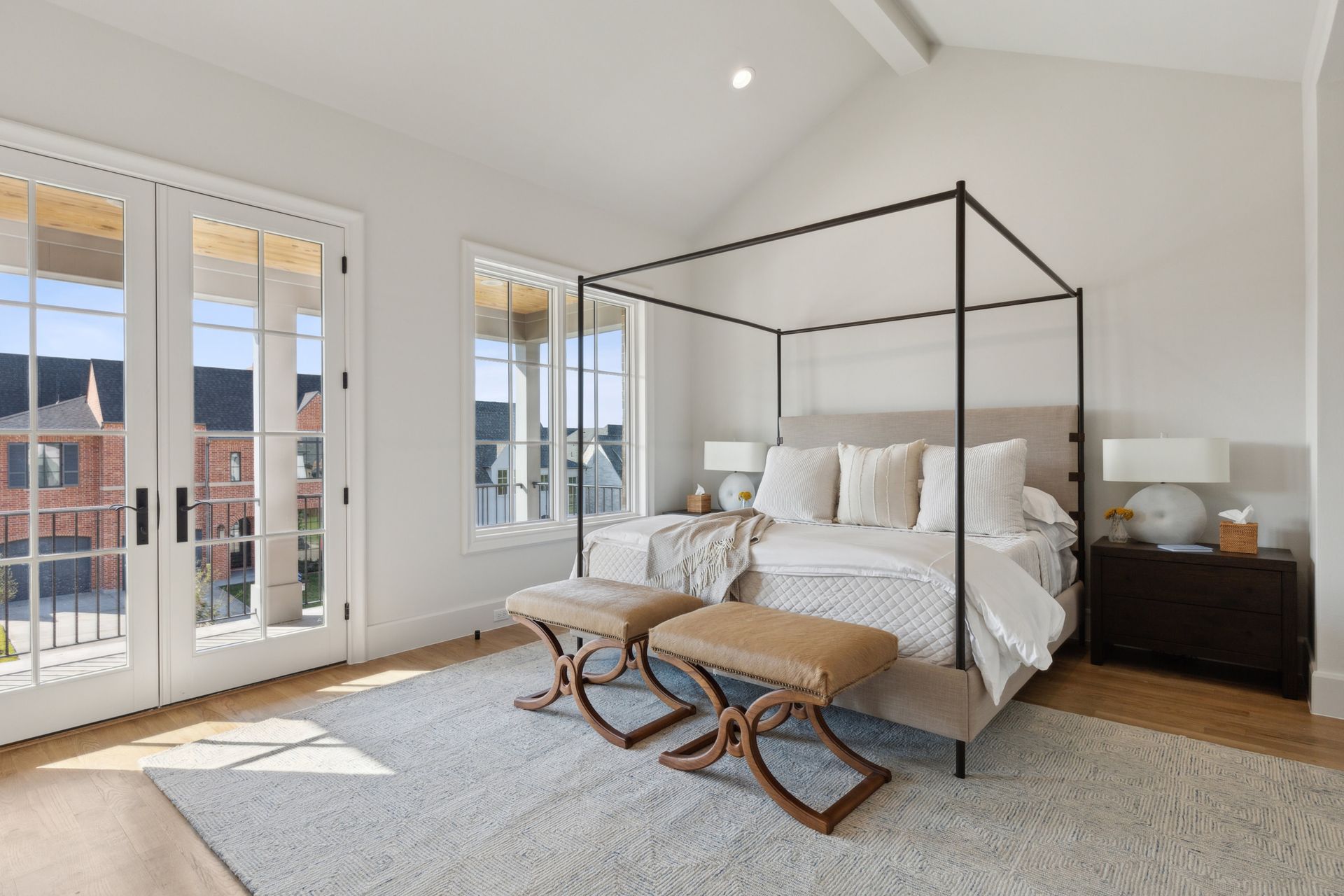 A bedroom with a canopy bed and two benches.