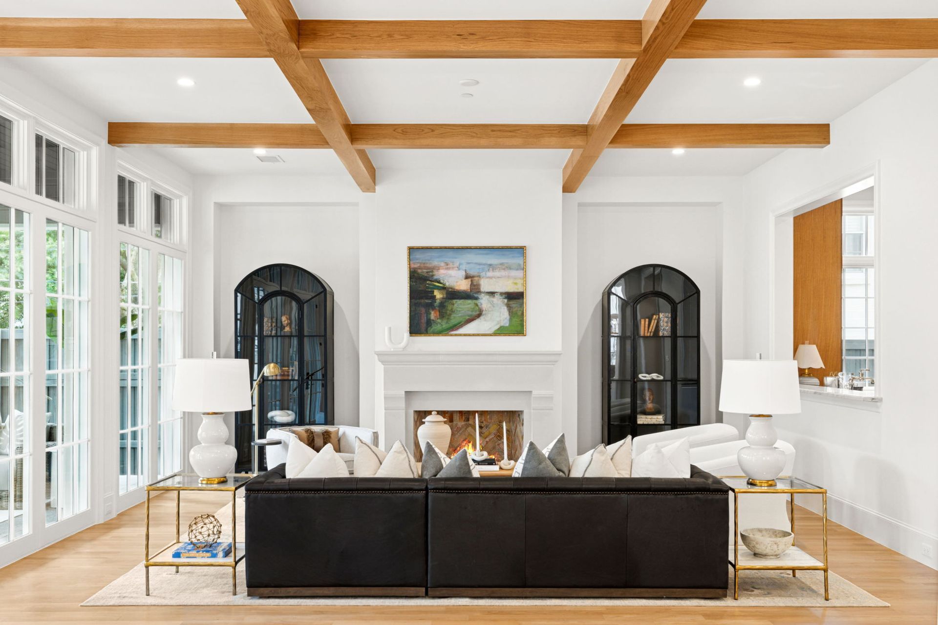 A living room with a black couch and a fireplace.
