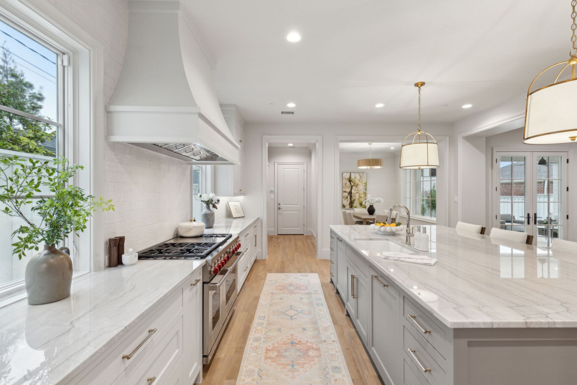 Bright, modern kitchen with gray island, white cabinets, and stainless steel appliances.