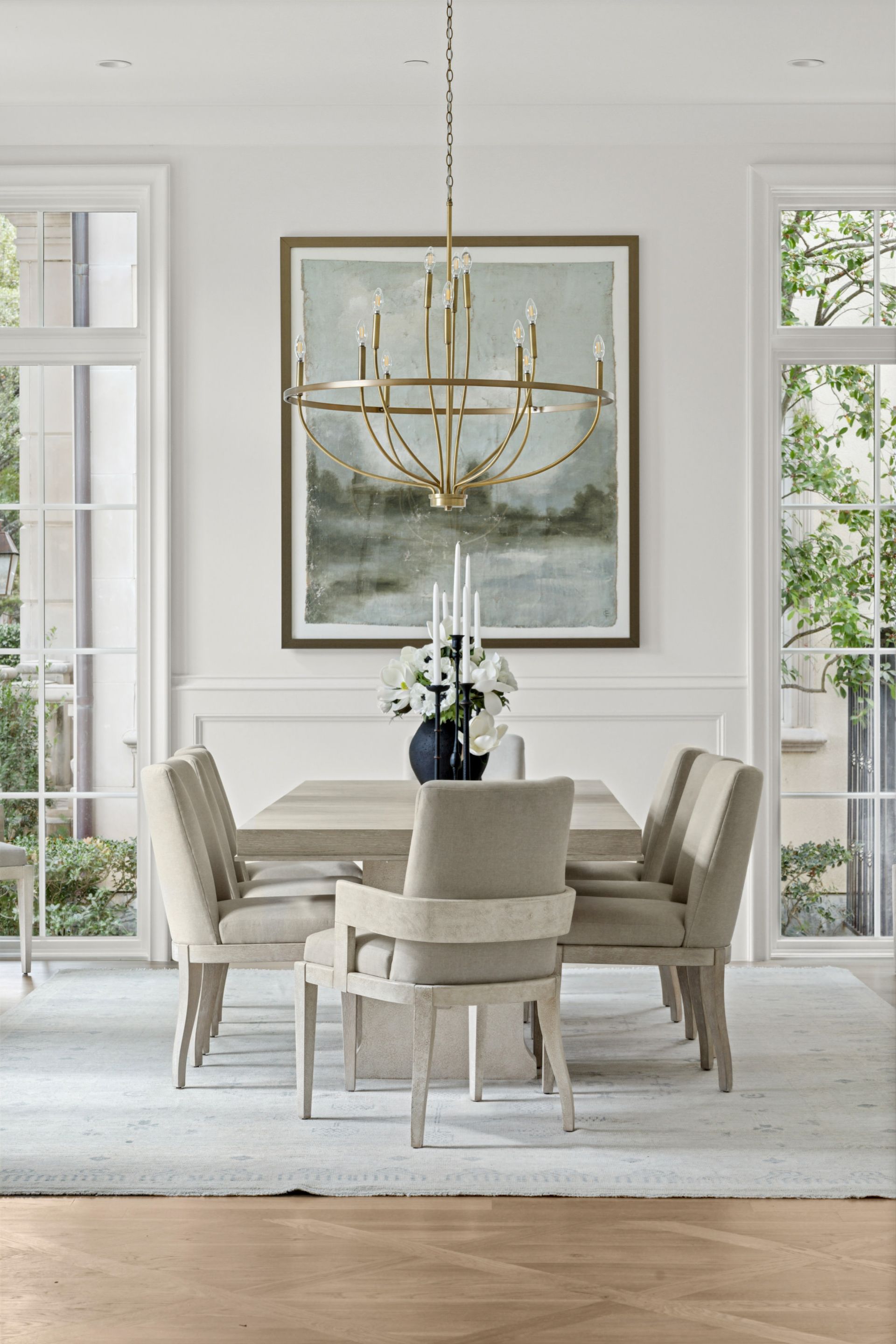 A dining room with a table and chairs and a chandelier hanging from the ceiling.