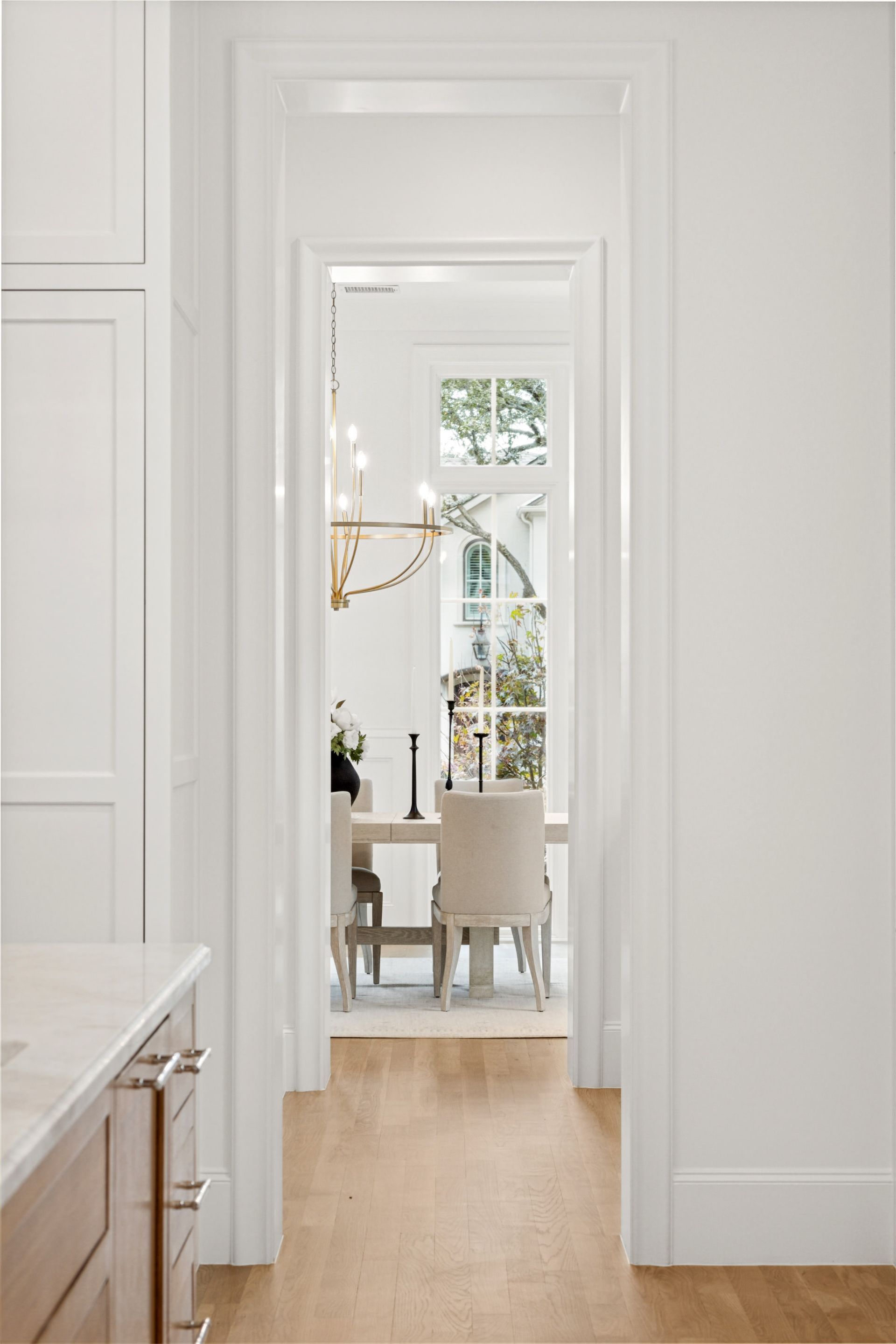 A hallway leading to a dining room with a table and chairs.