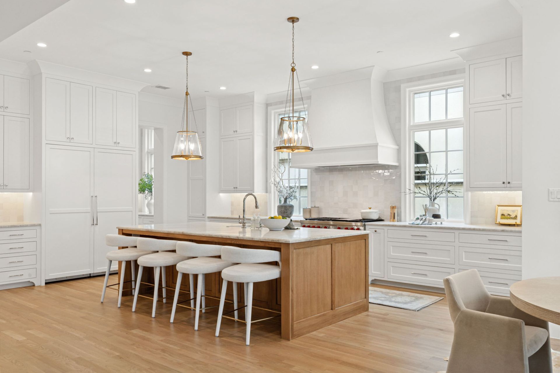 A kitchen with white cabinets and a large wooden island.