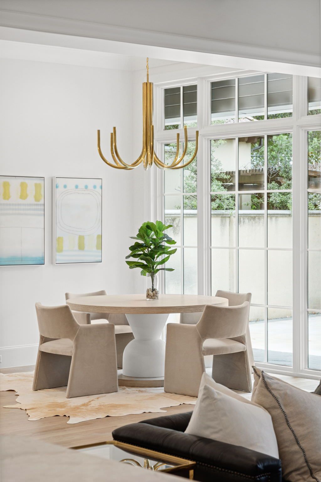 A dining room with a table and chairs and a chandelier hanging from the ceiling.