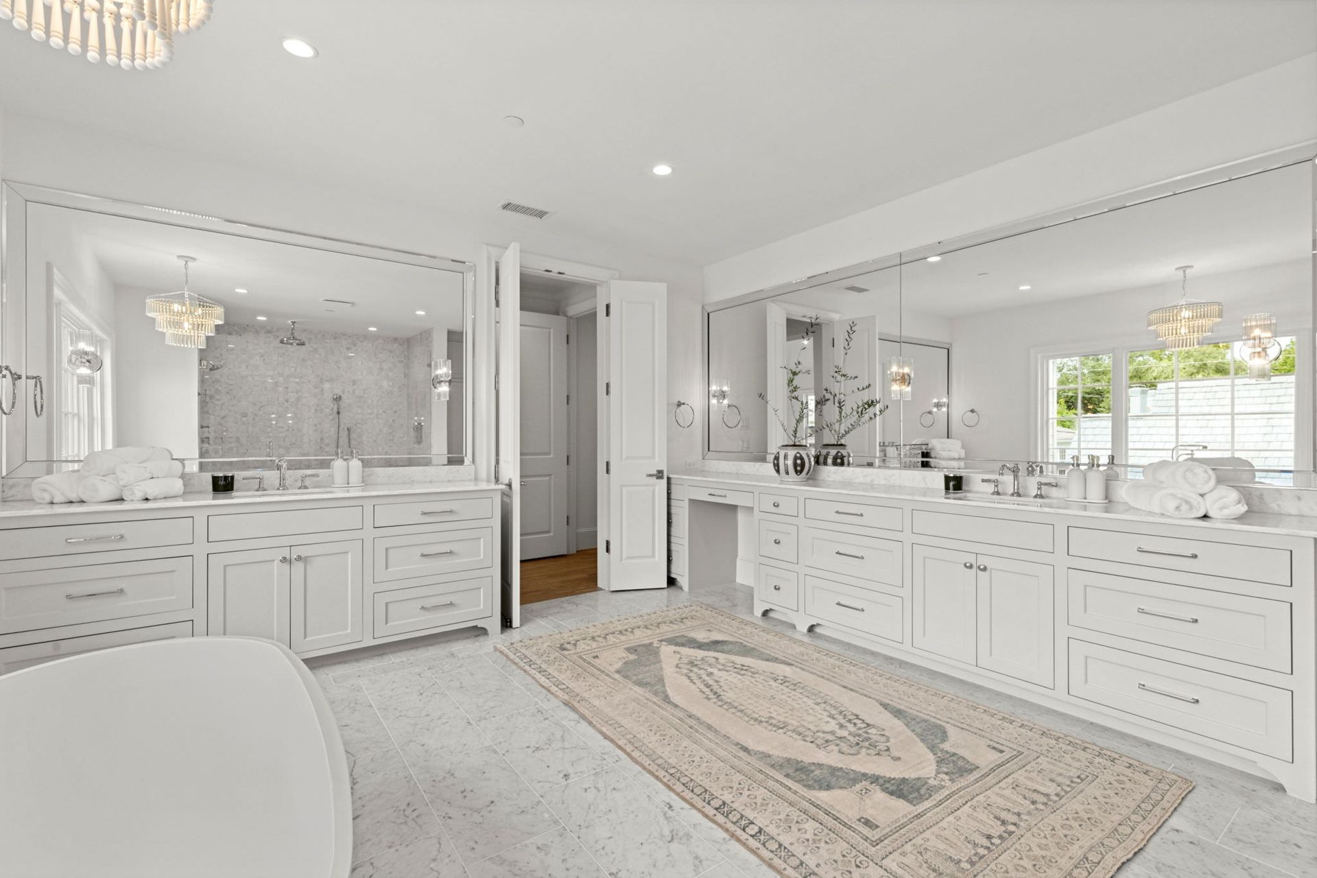 A large bathroom with two sinks , a bathtub , and a rug.