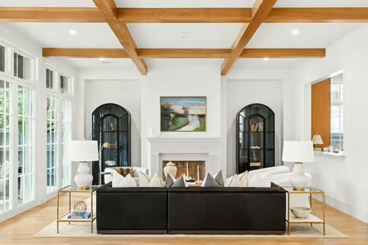 A living room with a black couch and a fireplace.