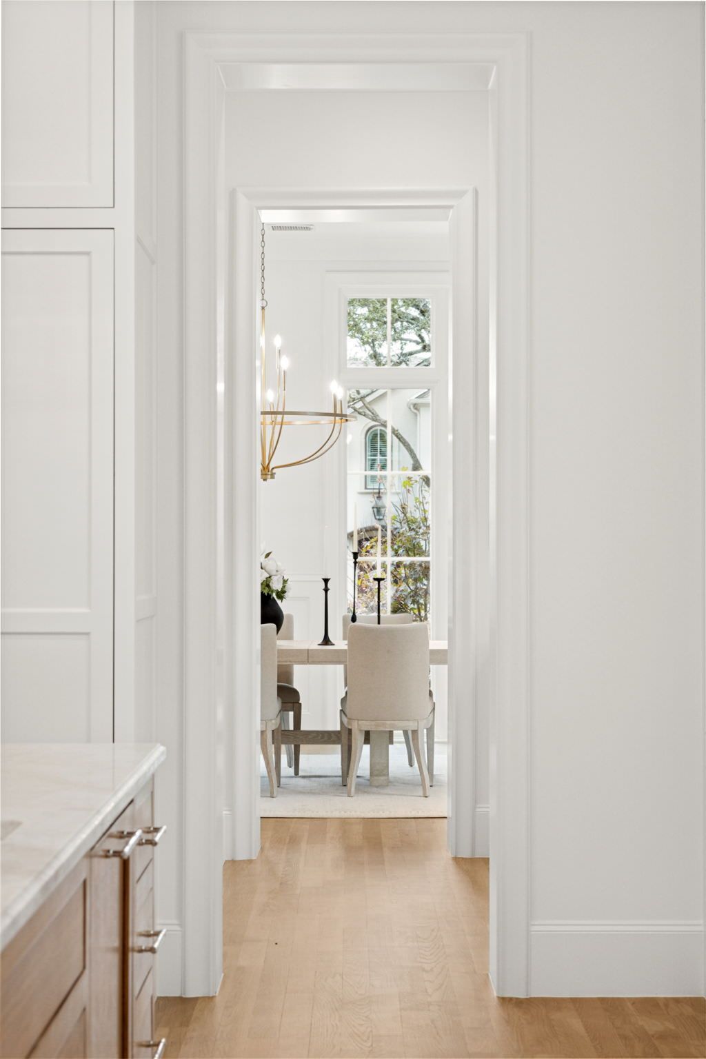 A hallway leading to a dining room with a table and chairs.