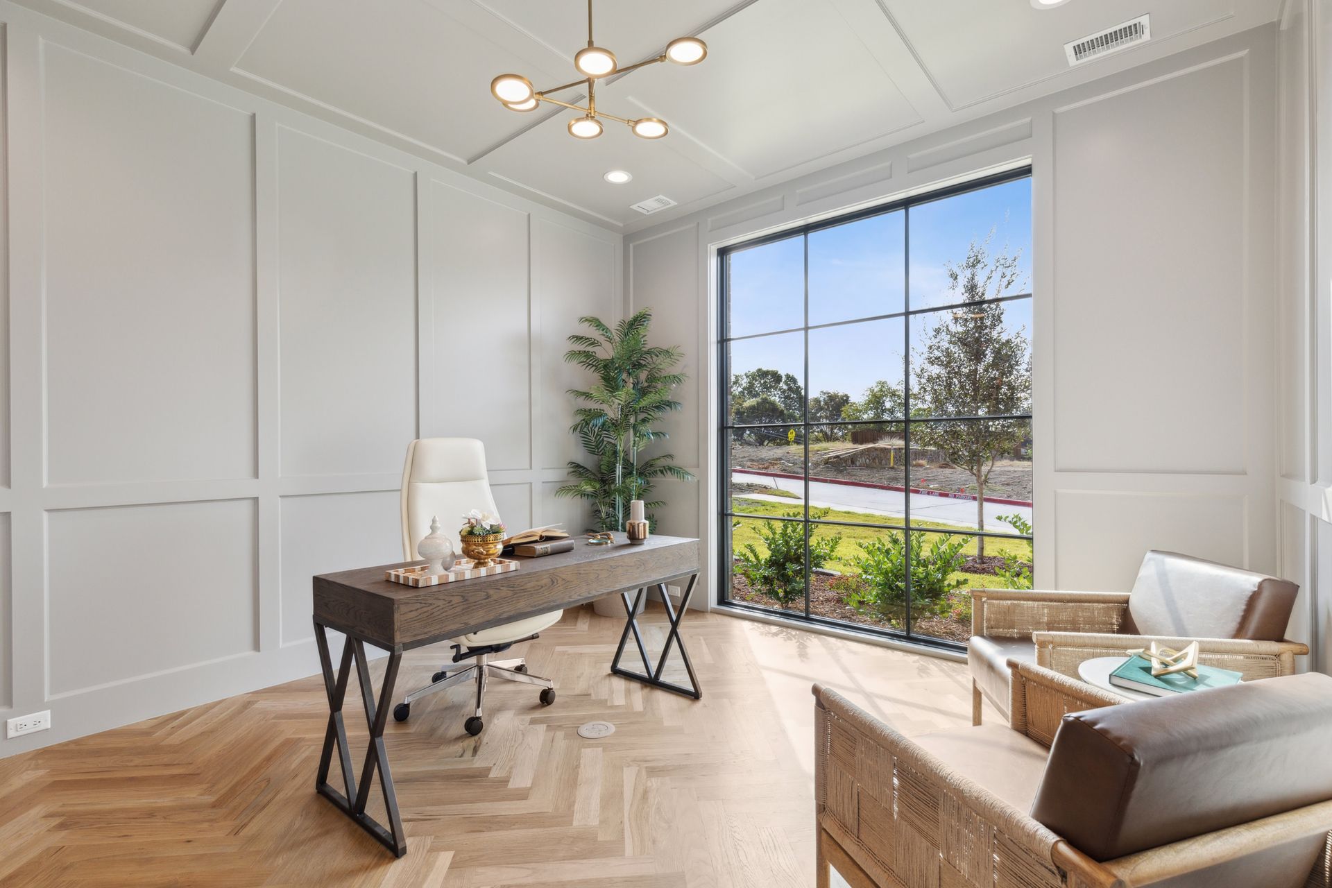 A home office with a desk , chair , and large window.