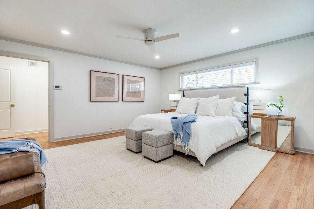 A bedroom with a large bed and a ceiling fan.