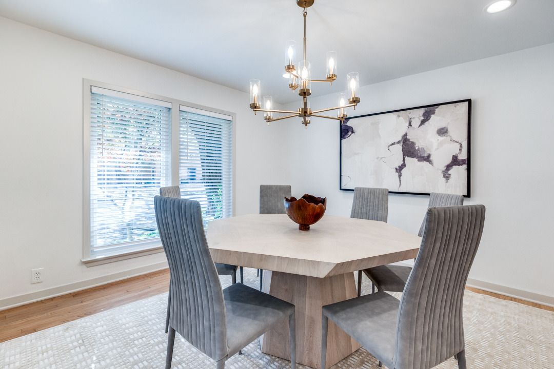 A dining room with a table and chairs and a chandelier.