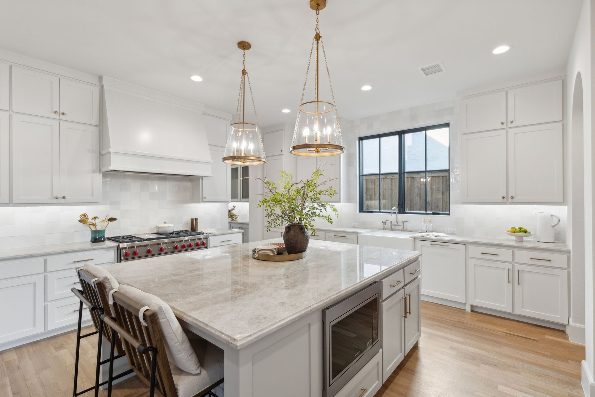 A kitchen with white cabinets , granite counter tops , stainless steel appliances and a large island.