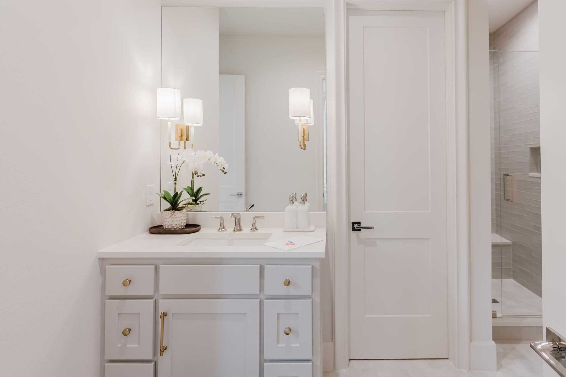 A bathroom with a sink , mirror , and cabinets.