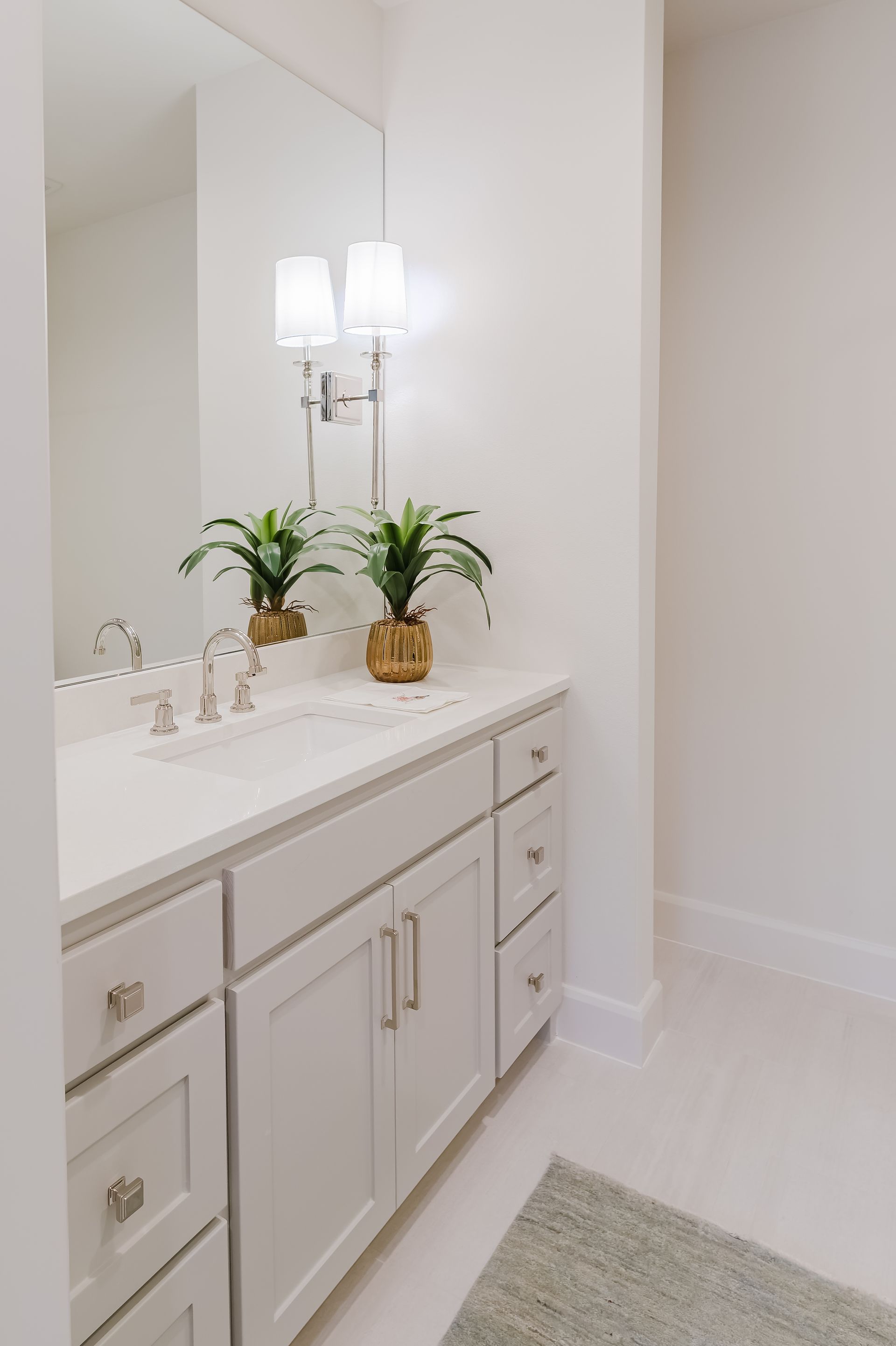 A bathroom with two sinks , a mirror , and a rug.