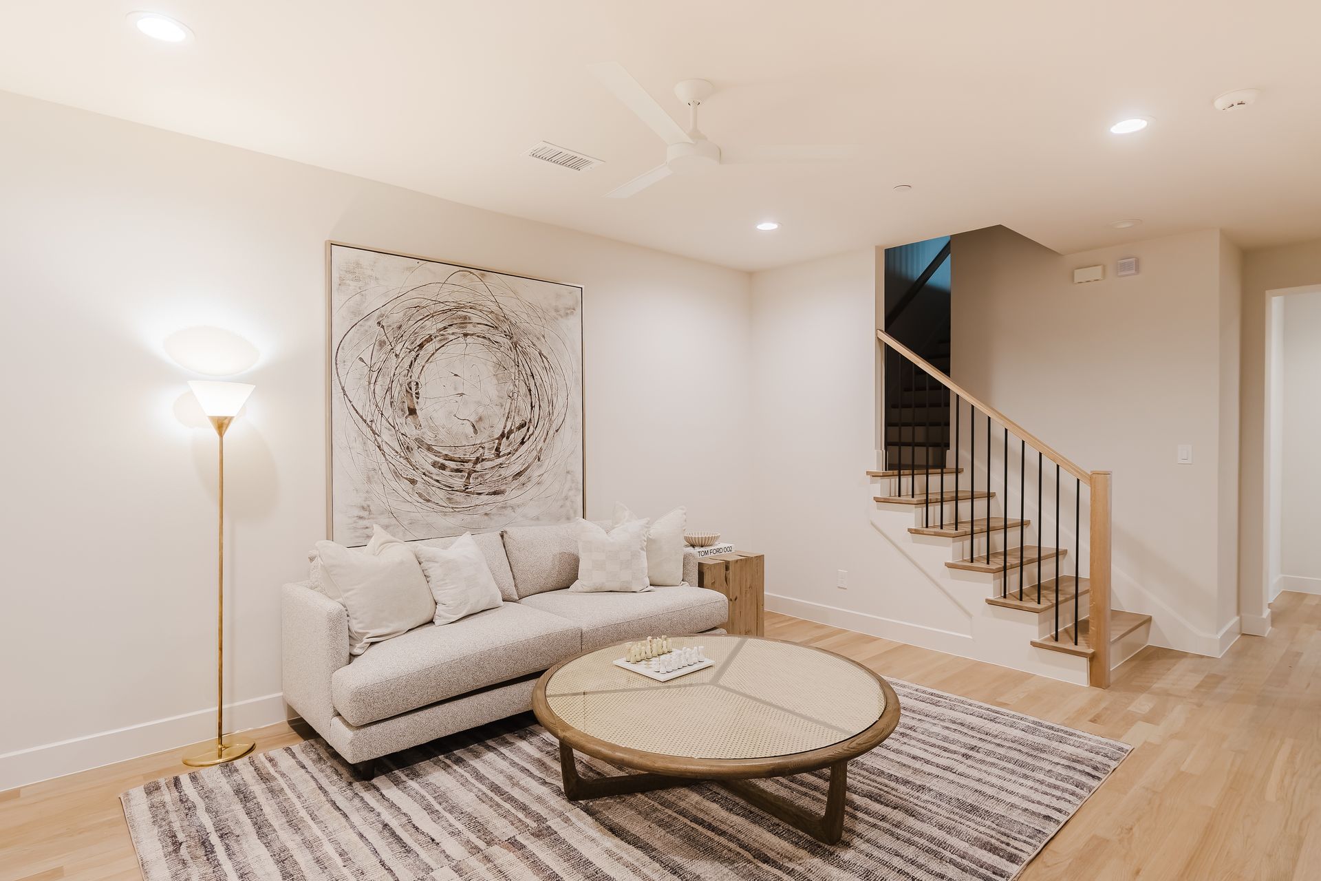 A living room with a couch , coffee table , and stairs.