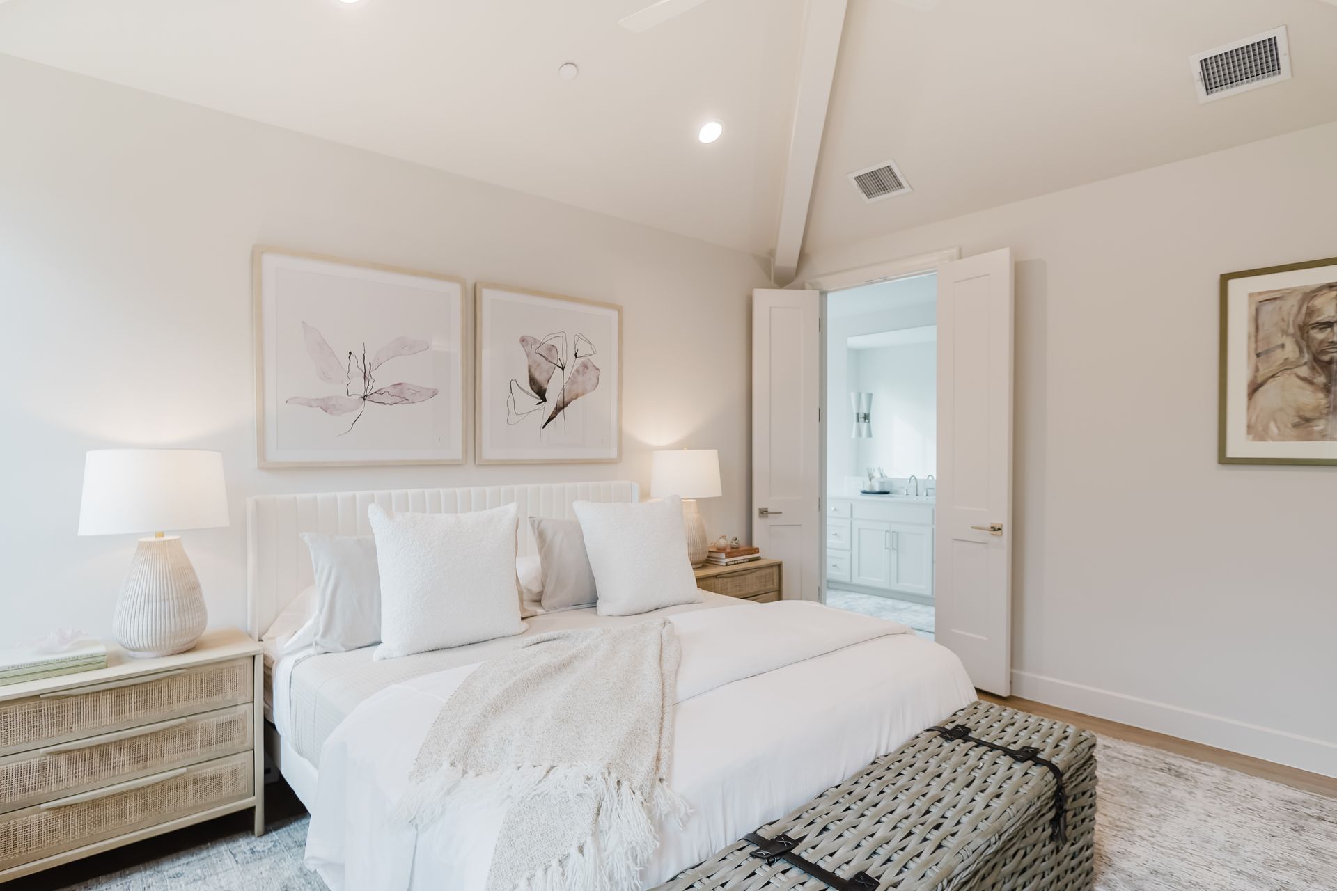 A bedroom with a bed , dresser , nightstand , lamps and a bench.