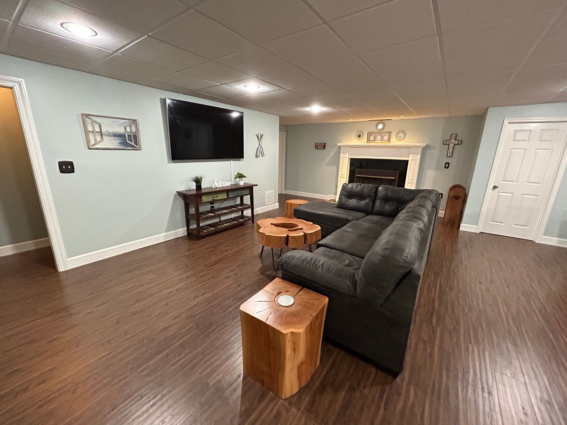 A living room with a couch , table , television and fireplace.